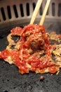 Chopstick stirring a mix of meat and egg