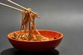 Chopsticks with asian schezwan noodles from bowl