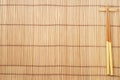 Chopsticks on brown bamboo matting background