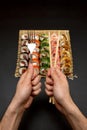 Chopsticks and fork in hand with sushi on black background Royalty Free Stock Photo