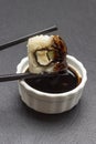 Chopsticks hold sushi over a bowl of soy sauce Royalty Free Stock Photo