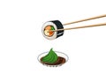 Chopsticks holding sushi dipping wasabi and soy sauce. Royalty Free Stock Photo