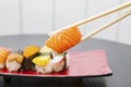 Chopsticks holding tasty sushi of salmon