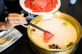 Chopsticks inserting sliced lamb into hotpot Royalty Free Stock Photo