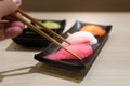 Chopsticks with Japan raw tuna sushi and fresh mix sushi set in Royalty Free Stock Photo