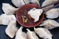 Chopsticks pick up the dumplings on the plate and dip them into the vinegar and chili sauce