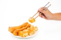 Chopsticks reaching for a piece of You Tiao, or fried bread stic