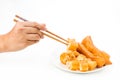 Chopsticks reaching for a piece of You Tiao, or fried bread stic Royalty Free Stock Photo