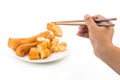 Chopsticks reaching for a piece of You Tiao, or fried bread stic Royalty Free Stock Photo