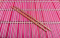 Chopsticks on red bamboo matting background Royalty Free Stock Photo