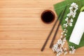 Chopsticks, sakura branch, soy sauce and bamboo mat