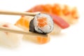 Chopsticks with salmon sushi roll Royalty Free Stock Photo