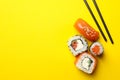 Chopsticks and sushi rolls on background, space for text. Japanese food Royalty Free Stock Photo