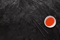 Chopsticks and sweet and sour sauce bowl on black slate stone. Royalty Free Stock Photo