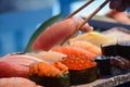 Chopsticks taking one piece of Otoro from Sushi Set nigiri and sushi rolls serving with soy sauce, Japan famous cuisine Royalty Free Stock Photo