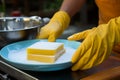 Daily chore closeup Gloved hand wields a sponge, post meal cleanup in the kitchen