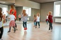 Choreography class. Group of active children dancing in front of the large mirror while having choreography class in the