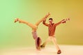 Choreography. Two talented people, autistic man and woman in vintage clothes dancing against gradient green yellow
