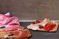 Chorizo, jamon and other Spanish meat appetizer on black wooden background.