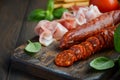 Chorizo sausage. Spanish traditional chorizo sausage and ham with fresh herbs and tomatoes. Royalty Free Stock Photo