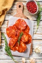 Chorizo sausage thin cut on a cutting board. Spanish salami with spices, paprika, pepper. Spicy food. White background. Top view Royalty Free Stock Photo