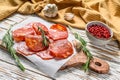 Chorizo sausage thin cut on a cutting board. Spanish salami with spices, paprika, pepper. Spicy food. White background. Top view Royalty Free Stock Photo