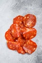 Chorizo sausage thin cut. Spanish salami with spices, paprika, pepper. Spicy food. White background. Top view Royalty Free Stock Photo