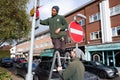 Chorleywood Parish Council rangers putting up Remembrance Poppy on lamp post in Chorleywood village center