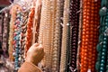 Chosing some jewellery necklaces of shiny beads from market