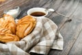 Choux cake with coffee on a wooden background. In a basket on a checkered towel. View from above. Chic with cottage cheese. Small
