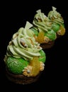 Choux pastry desserts with oranges, pistachio ganache and white chocolate decorations