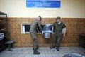 At a chow hall: kitchen workers carrying pot with ready meal for soldiers