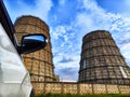 CHP cooling towers from which smoke is coming out against blue sky. A large pipe of a thermal power plant with smoke and Royalty Free Stock Photo