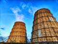 CHP cooling towers from which smoke is coming out against blue sky. A large pipe of a thermal power plant with smoke and Royalty Free Stock Photo