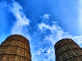 CHP cooling towers from which smoke is coming out against blue sky. A large pipe of a thermal power plant with smoke and Royalty Free Stock Photo
