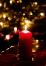 Chrismas eve at home, red candle lit and blurred lights Royalty Free Stock Photo