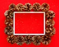 Chrismas red background with pine cones and white frame for space for text. Happy new year and Merry Xmas post card Royalty Free Stock Photo