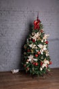 Chrismass tree with red bals and bow in fornt of bricks wall