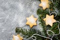 Chrismtas cookie stars and fir tree branches on gray background