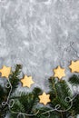 Chrismtas cookie stars and fir tree branches on gray background