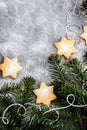 Chrismtas cookie stars and fir tree branches on gray background