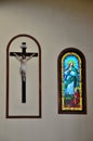 Christ on crucifix cross hanging on wall with stained glass window St Mary`s cathedral church Jaffna Sri Lanka