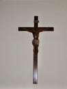 Christ statue in the church.Tiny wooden crucifix with metal Jesus hanging on the white pastel wall Royalty Free Stock Photo