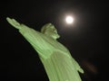 Christ statue with full moon and black sky. Icon of Christianity and Catholic faith exposed at Brazil, South America Royalty Free Stock Photo