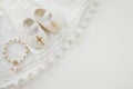 Christening background with baptism baby dress, shoes, and cross on pastel background Royalty Free Stock Photo