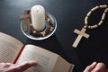 Christian reading the bible on nightstand with religious elements