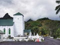 Christian Church of the Cook Islands in Avarua, Rarotonga, with surrounding mountains in a cloudy day
