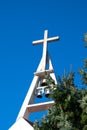 Christian church cross with bells on blue sky. Symbol of religion. Catholic church in Poland and bell tower with cross