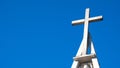 Christian church cross with bells on blue sky. Symbol of religion. Catholic church in Poland and bell tower with cross