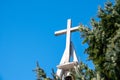 Christian church cross with bells on blue sky. Symbol of religion. Catholic church in Poland and bell tower with cross
